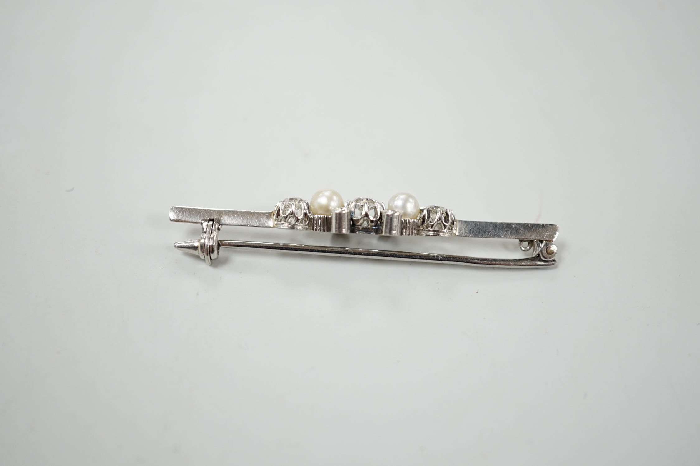 A white metal, diamond and cultured pearl cluster set bar brooch, 52mm, gross weight 6.2 grams.